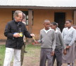 James Smith handing out school supplies to students in Sakila, Tanzania