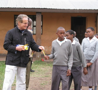 James Smith handing out school supplies to students in Sakila, Tanzania